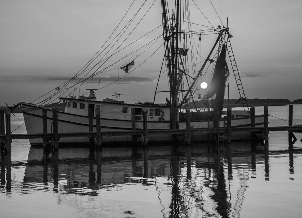 Sunset on a shrimp boat moored at the Port Royal harbor, Georgia in black white