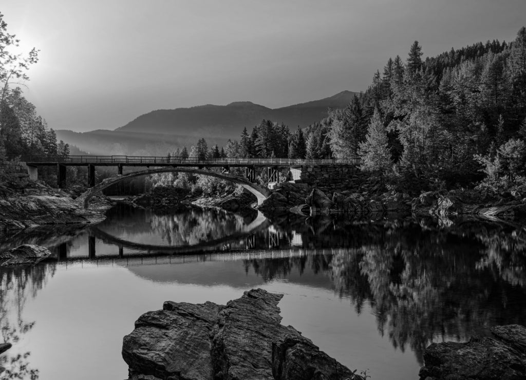 Sunrise across Belton Bridge over Middle Fork Flathead River near West Glacier in Glacier National Park, Montana in black white