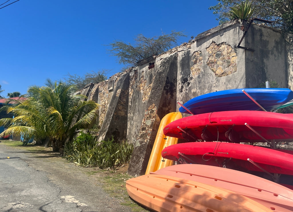 Old stone wall and rack of Kayaks on St Thomas waterfront, US Virgin Islands