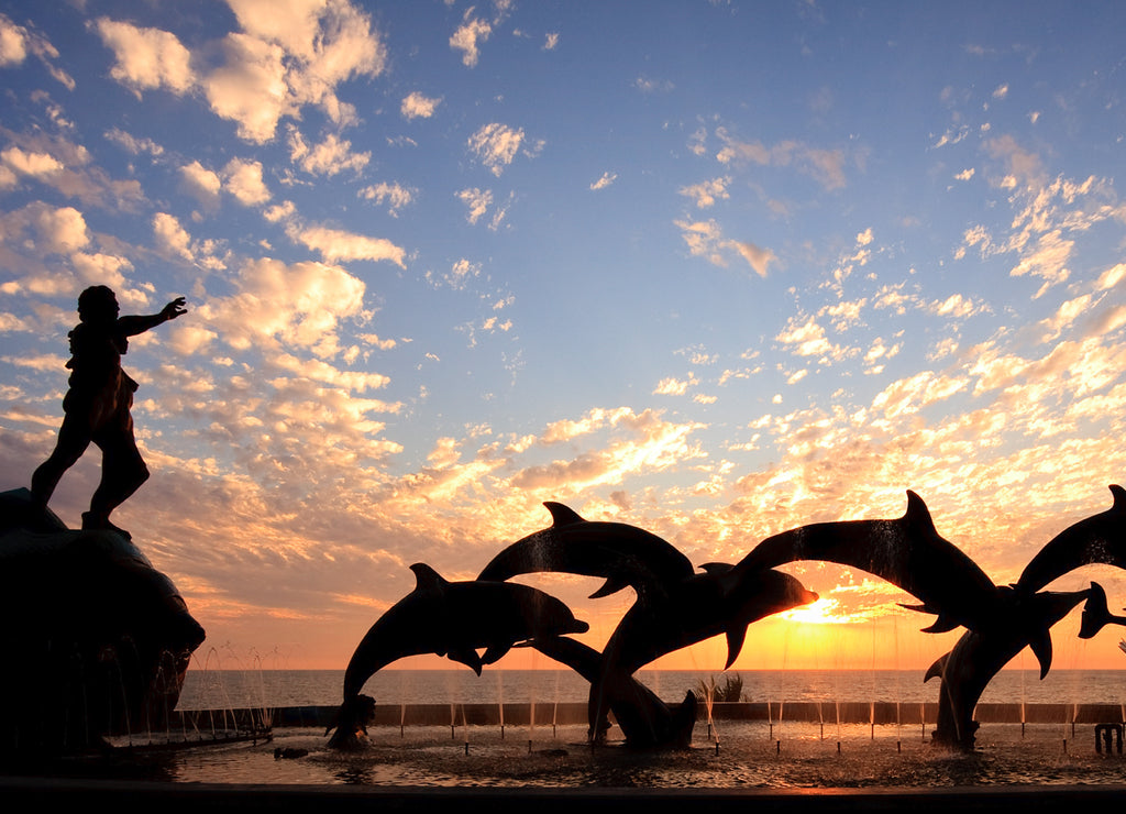 Dolphin statue in front of sunset, Mexico