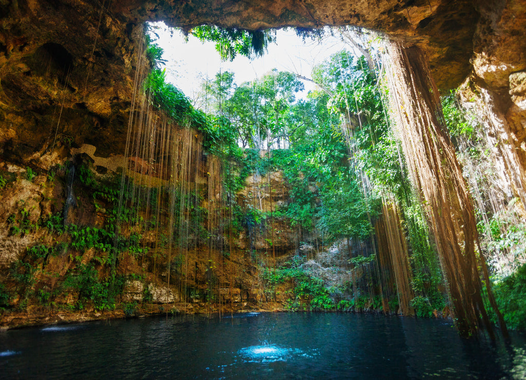 Piercing rays of sunlight at the cenote entrance of Ik-Kil, Mexico
