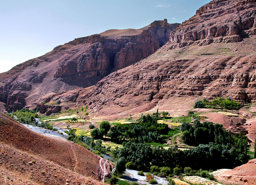 Mountain scenery of Afghanistan near Yakawlang in Bamyan (Bamiyan) Province. These colorful mountains are at the western end of the Hindu Kush mountain range in Central Afghanistan. River and trees
