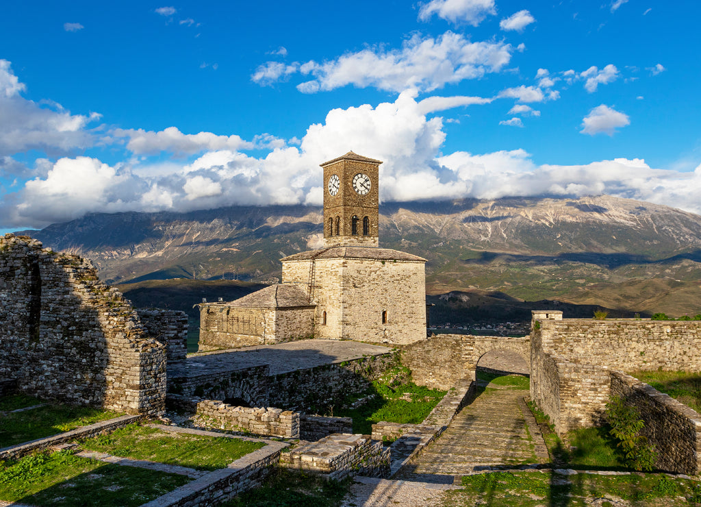 Scenic view of clock tower in castle of Gjirokastra with mountains and clouds