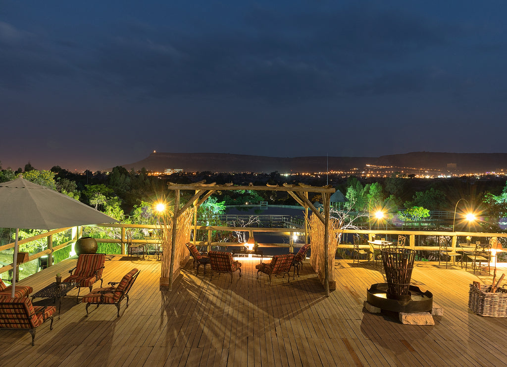 Wooden porch overlooking the Lubango lake and mountains. Night image. Angola