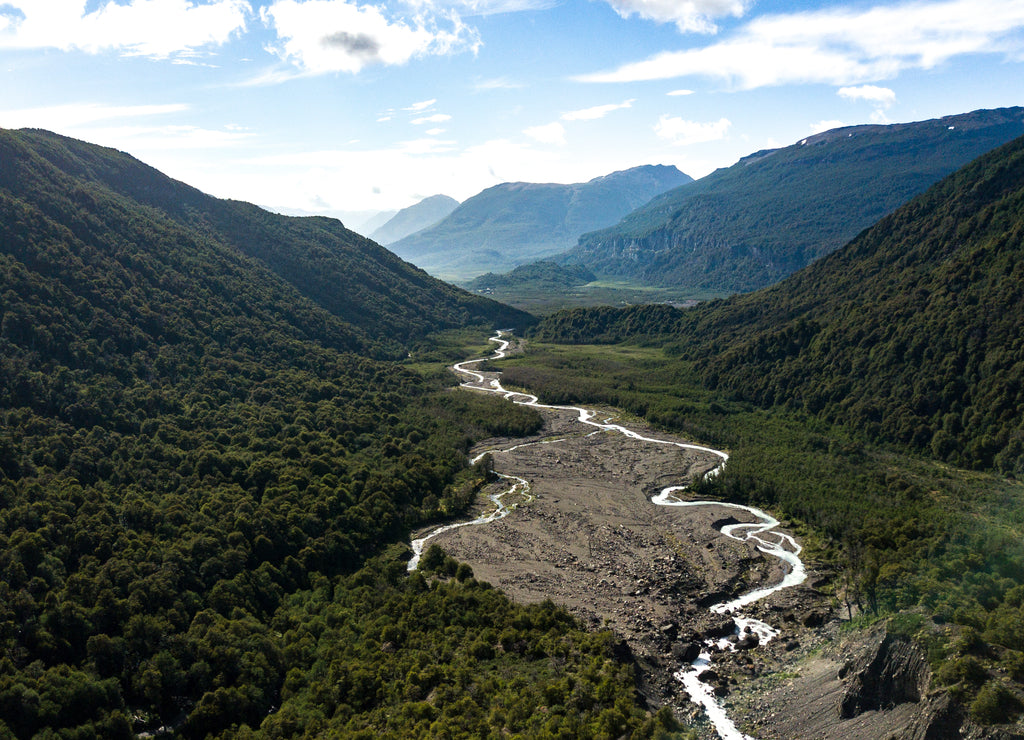 Aerial view on green valley with river stream surrounded by mountains. Nahuel Huapi National Park in Patagonia, Argentina