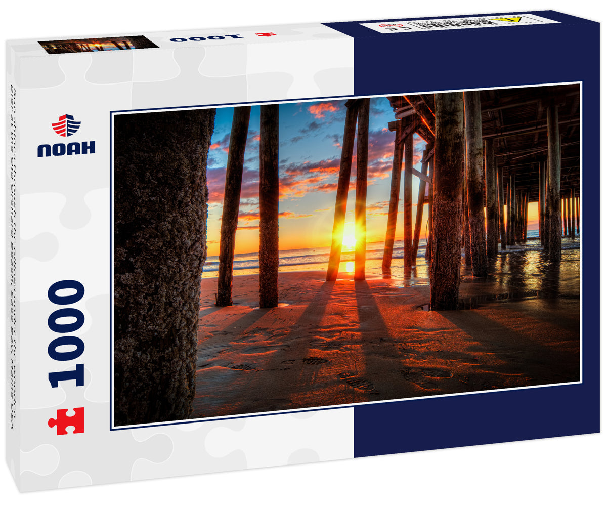 Sun shines through the pilings under the wooden pier at the Old Orchard Beach, Saco Bay, Maine USA