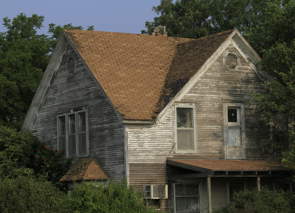 old farm house with tree's, blue sky, out in the country north of Lyons Kansas USA that's abandoned