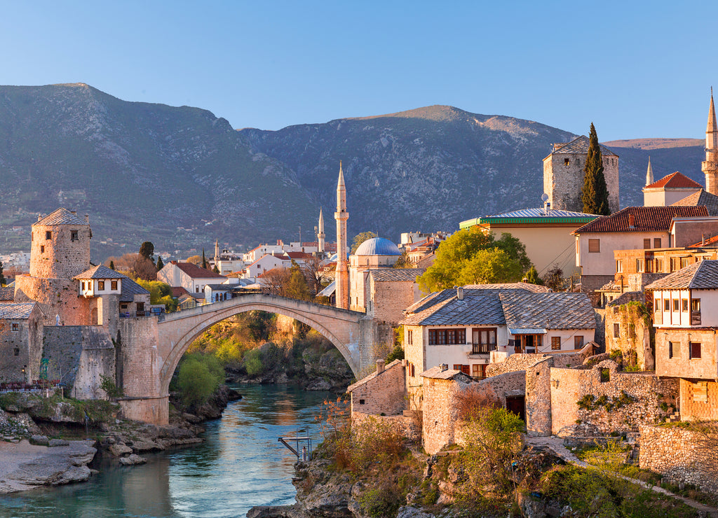 Skyline of Mostar with the Mostar Bridge, houses and minarets, at the sunset in Bosnia and Herzegovina
