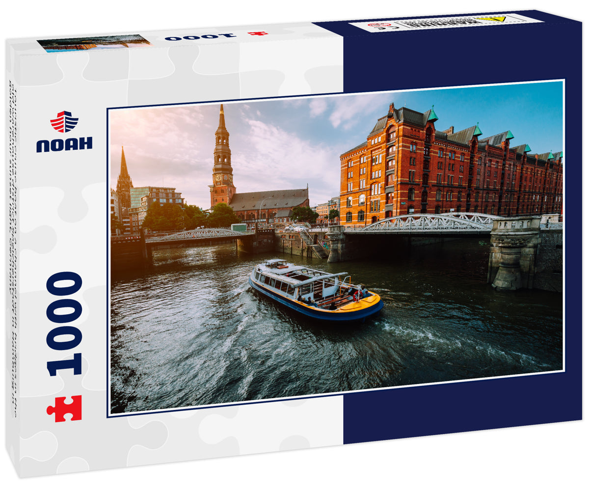 Touristic cruise boat on a channel with bridges in the old warehouse district Speicherstadt in Hamburg in golden hour sunset light, Germany