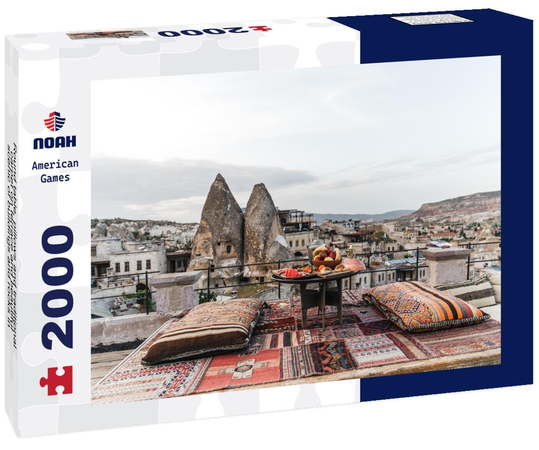 Noah Jigsaw Puzzle Round table, pillows and traditional carpet on terrace and beautiful scenic of buildings and rocks in Cappadocia, Turkey 2000 pieces