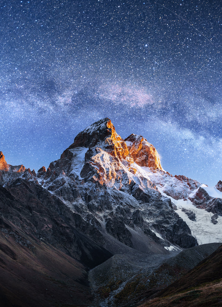 Fantastic starry sky. Autumn landscape and snow-capped peaks. Main Caucasian Ridge. Mountain View from Mount Ushba Meyer, Georgia. Europe