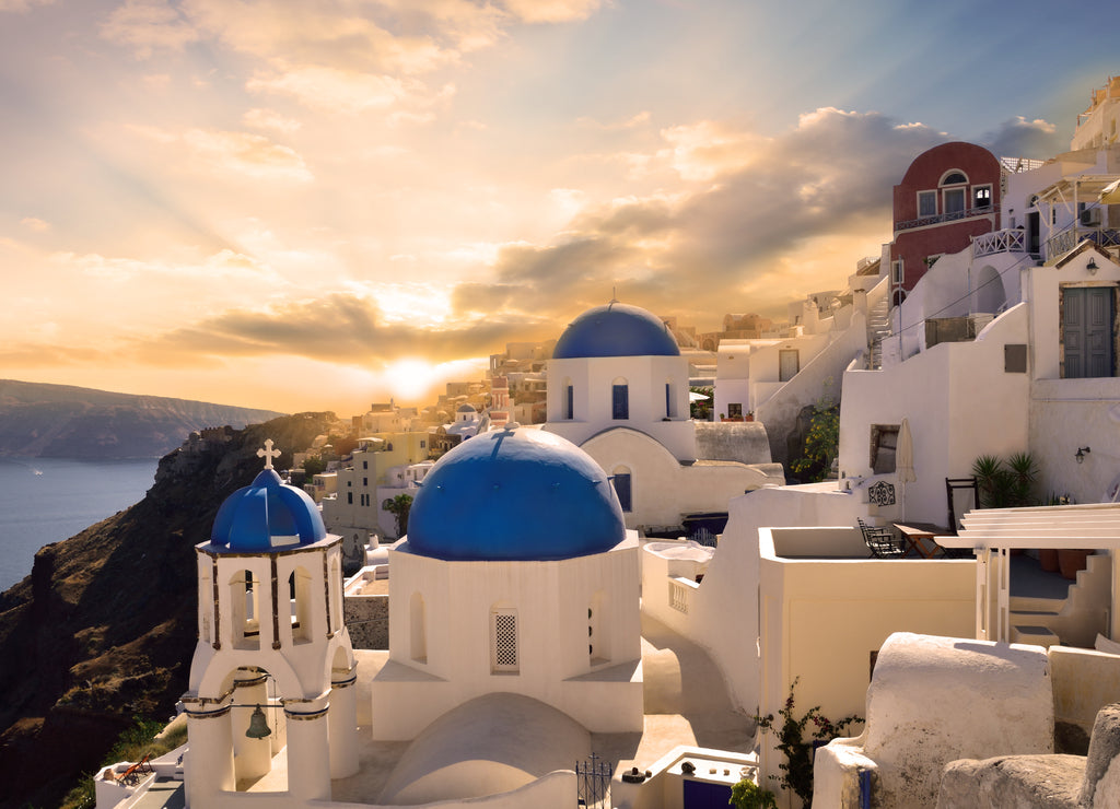 Traditional white architecture in Oia Santorini, illuminated by a beautiful sunset in Greece - Europe