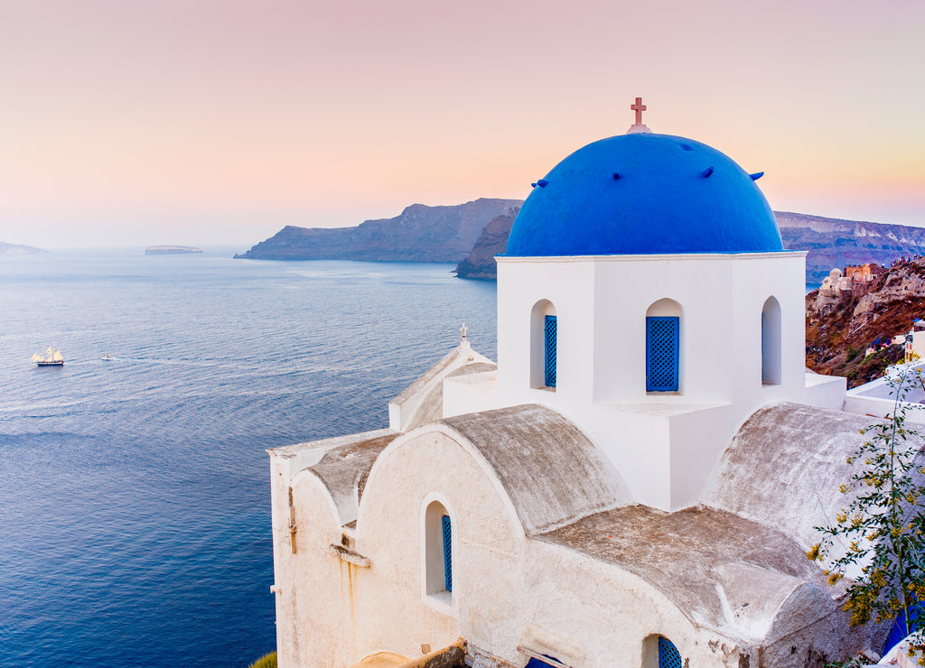 Picturesque view of Old Town Oia on the island Santorini, white houses, windmills and church with blue domes, Greece
