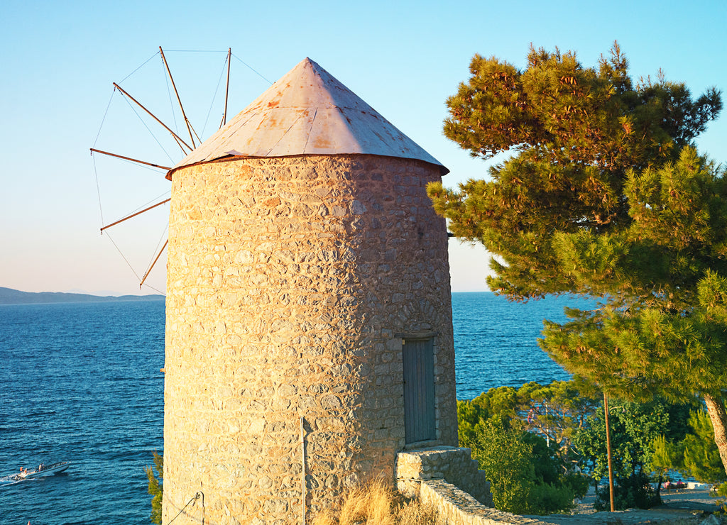 Beautiful view on old wind mill and sea on island Hydra, Greece on sunset time