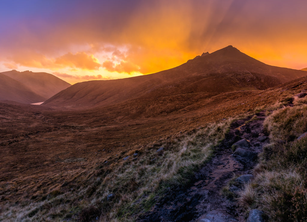 Beautiful valley with water reservoir in Mourne Mountains at golden hour and dramatic sunset. Mourne Mountains, highest range in Northern Ireland