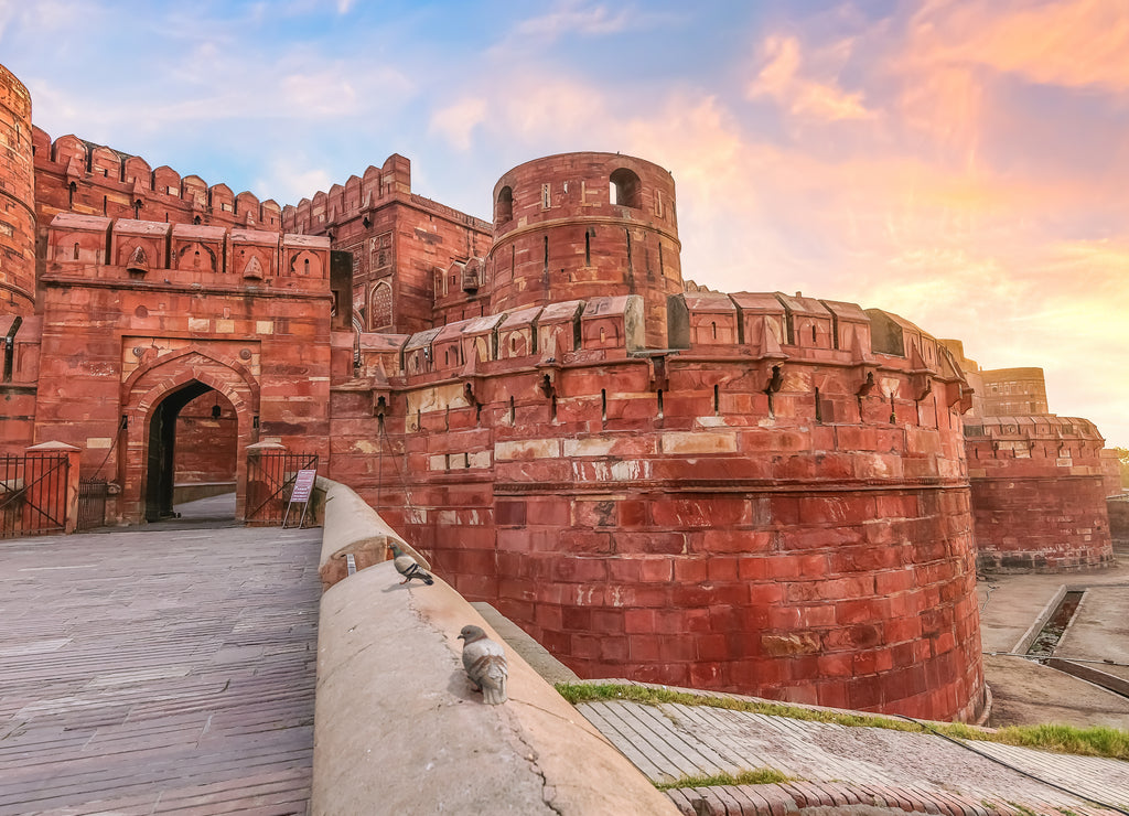 Historic medieval Agra Fort made of red sandstone at sunrise with moody sky. Agra Fort is a UNESCO World Heritage site
