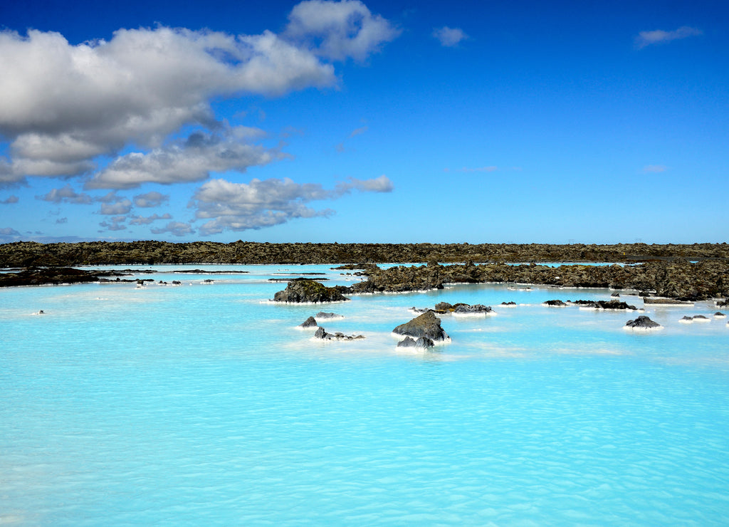 Blue landscape, blue sky, Blue lagoon geothermal springs and black lava covered with moss in between, Iceland
