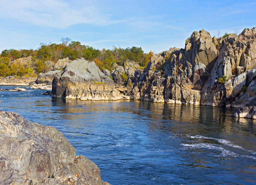 Mountainous banks of Potomac River on sunny day in autumn, Virginia, USA. A scenic river bend in Great Falls park, Virginia, USA