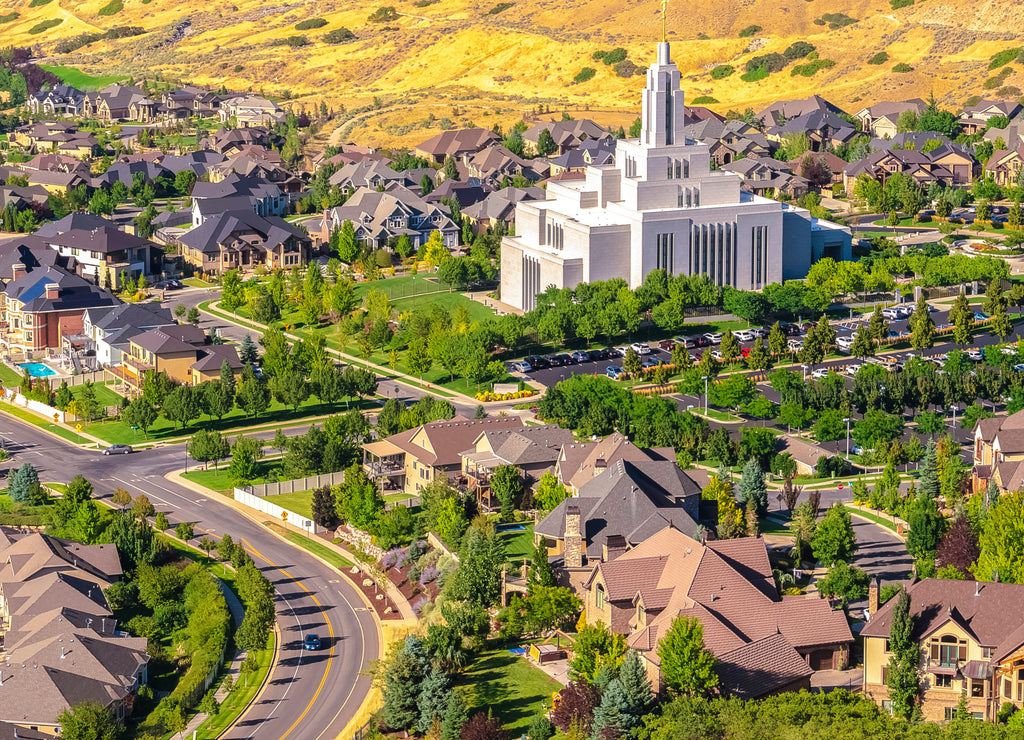 Square frame Salt Lake City Utah suburbs with a white temple towering over houses and roads