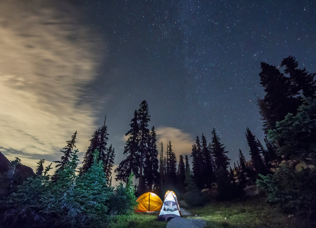 Tents glow under the stars in the woods near White Pine Lake in Utah
