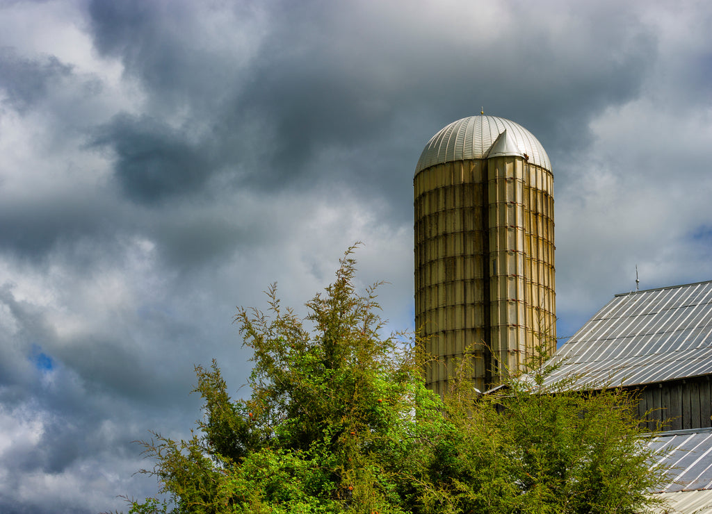 Stormy skies hang over a silo and barnroof in rural Tennessee