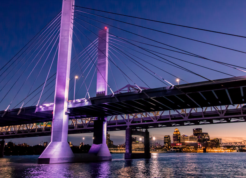 Louisville, Kentucky, USA downtown skyline from under the Abraham Lincoln bridge on the Ohio River at dusk