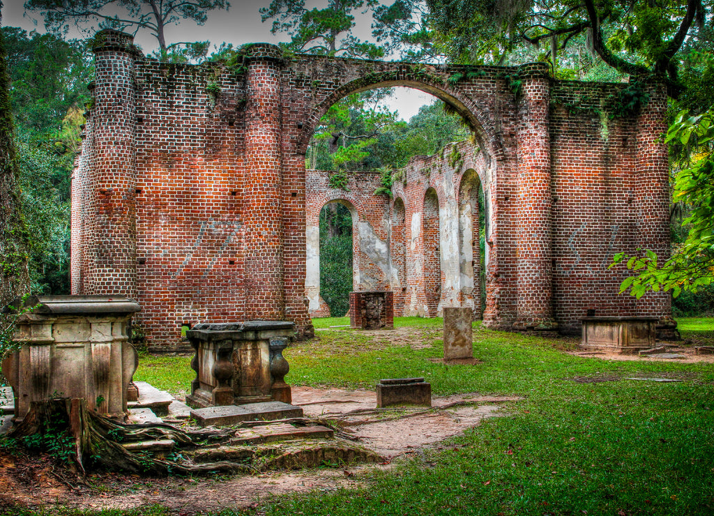 red brick skeleton of the Old Sheldon Church Ruins in Beaufort County, South Carolina with Spanish moss hanging from the surrounding trees