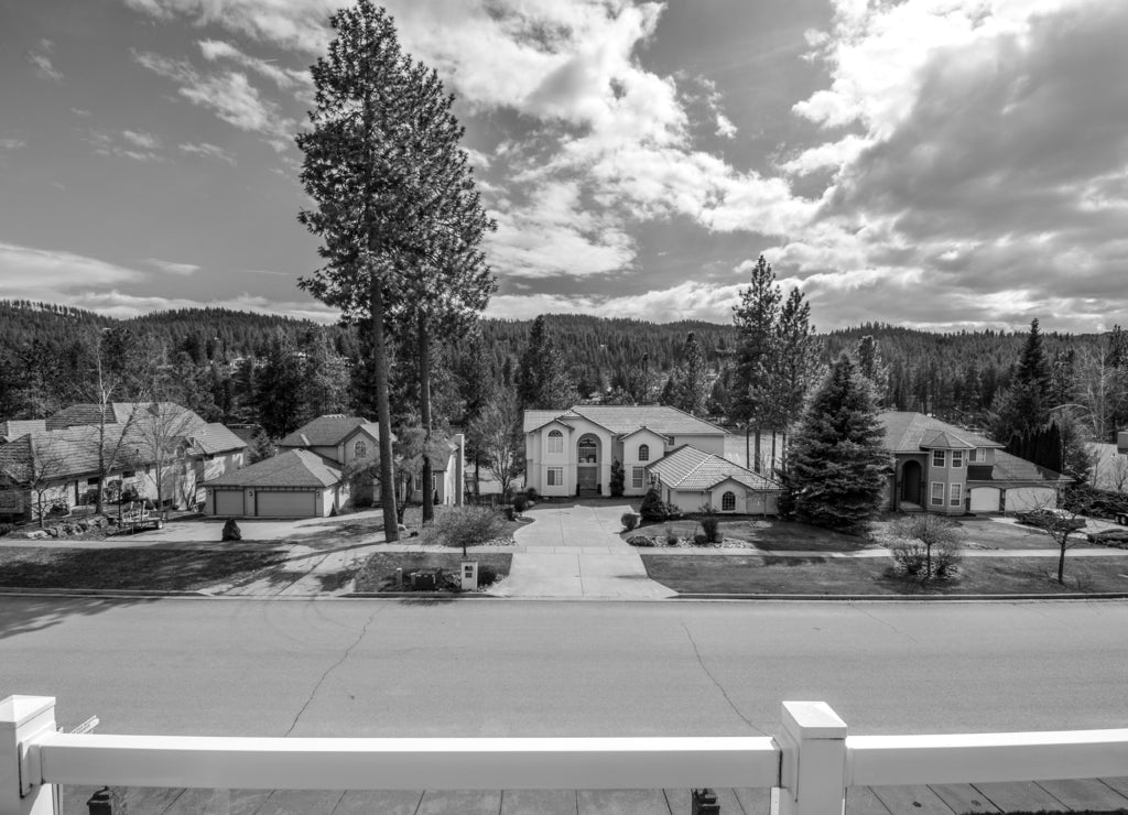 View from the balcony of a luxury home of the Spokane River, mountains and upscale homes in Post Falls, Idaho, USA in black white