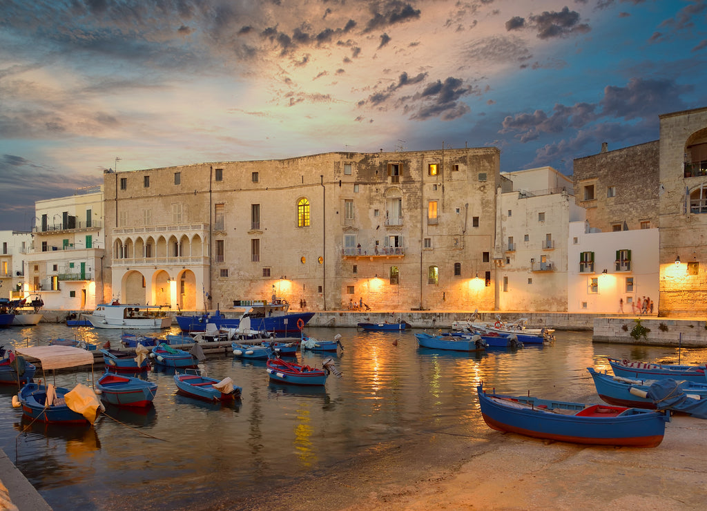 Fishing boats in Monipoli city bay with cloudy sky background, southern Italy