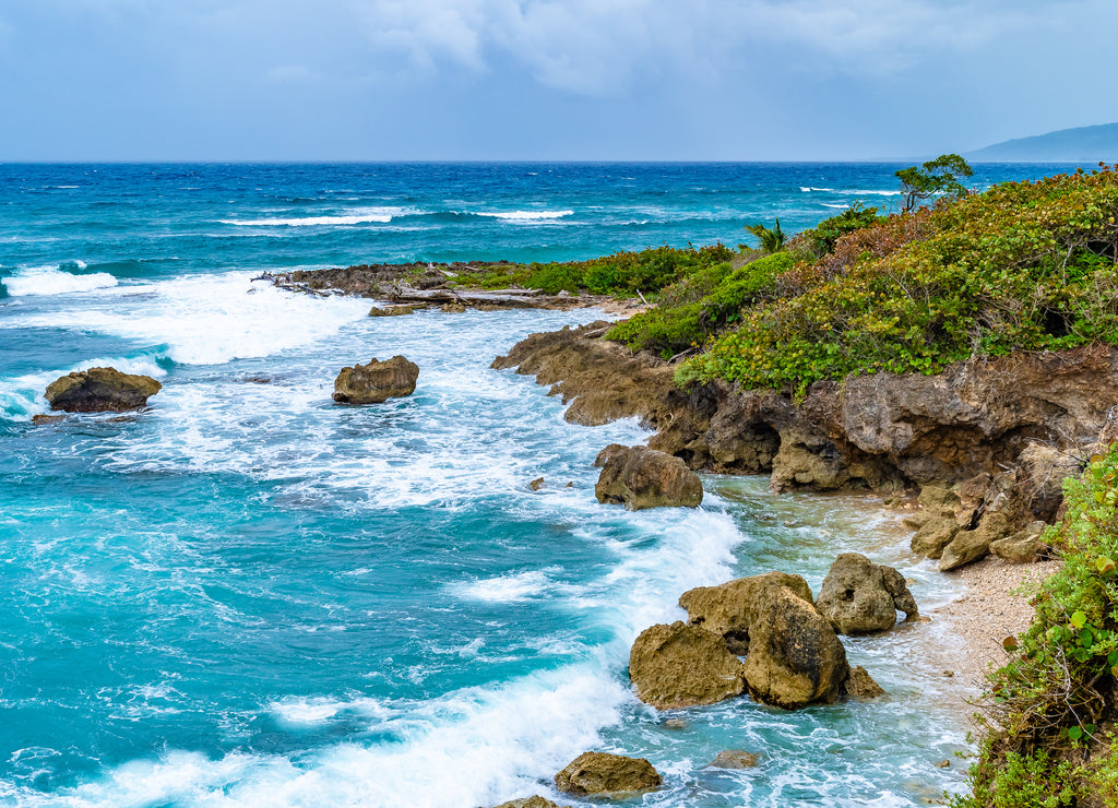Beautiful tropical Caribbean island landscape view. Scenic summer vacation ocean coast cliffs setting. High precipice coastline shore meets the sea. Coastal mountain rocks in Saint Mary parish,Jamaica