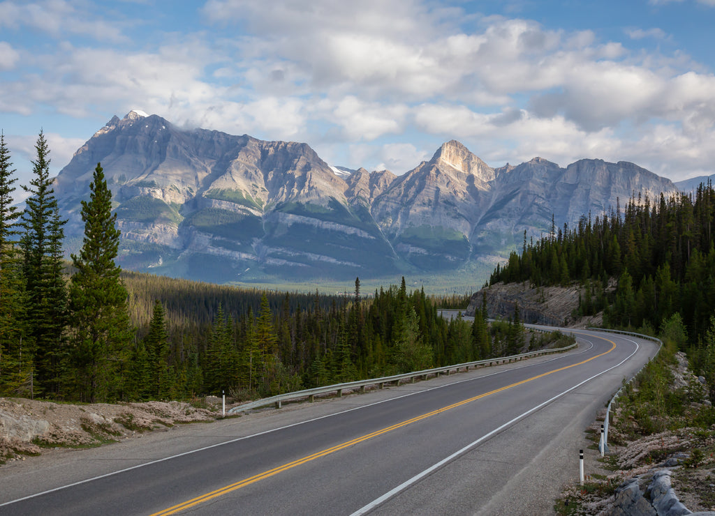Scenic road in the Canadian Rockies during a vibrant sunny and cloudy summer morning. Taken in Icefields Parkway, Banff National Park, Alberta, Canada