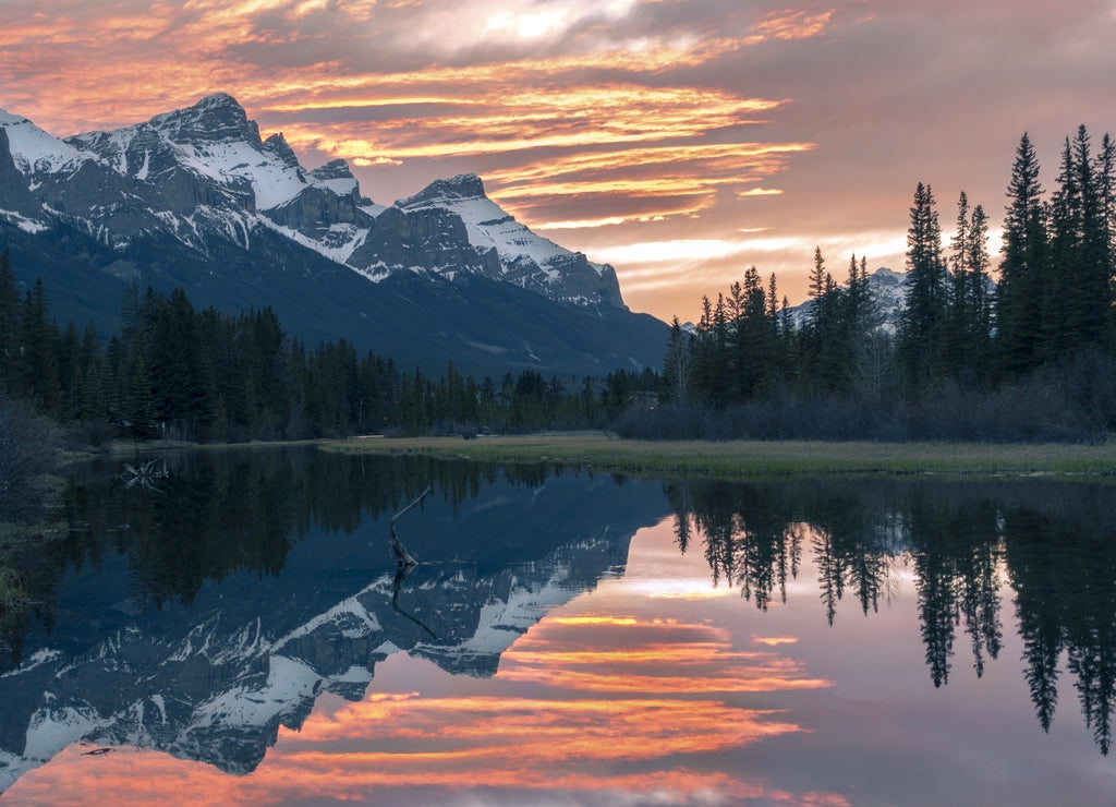 Scenic Sunset Evening Colors at Canmore Spring Creek Mountain Village and Distant Snowy Rocky Mountain Peaks Landscape in early Springtime, Alberta Canada