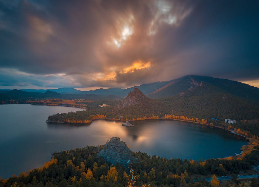 Dramatic autumn evening cloudscape at sunset. The bright colors of autumn around mountain lake. Kazakhstan. Asia.