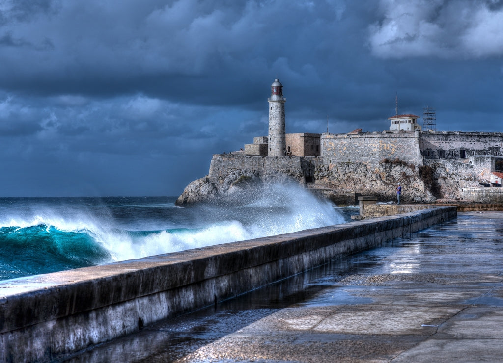 Cuba, Havana. Waves Breaking on the Malecon Sea Front. El Morro Fort in Background