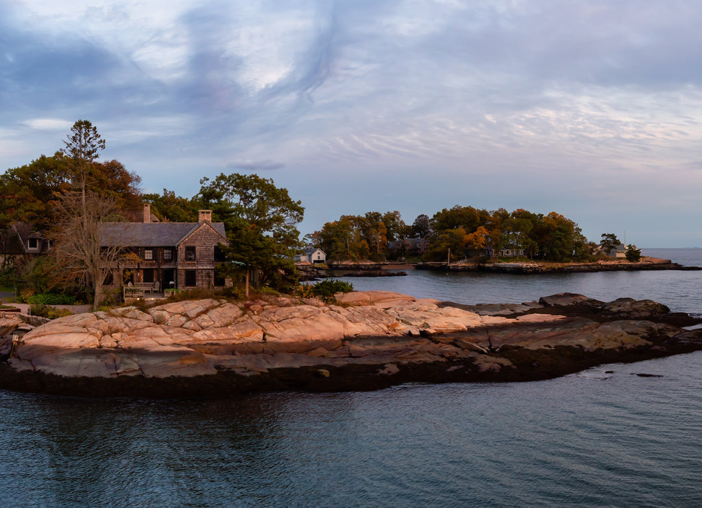 Panoramic seascape view of beautiful homes on a rocky Atlantic Coast during a vibrant sunset. Taken in New Haven, Connecticut, United States