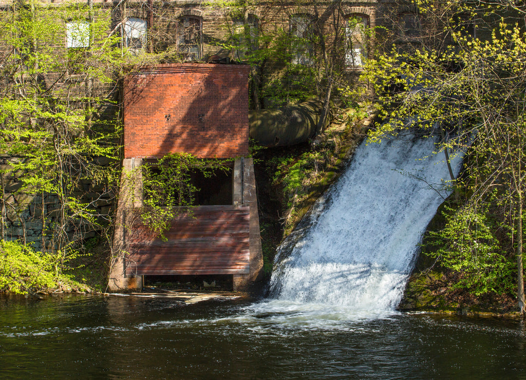 Water power sluice emerges from historic Dart's Stone Mill on the Hockanum River in Rockville, Connecticut