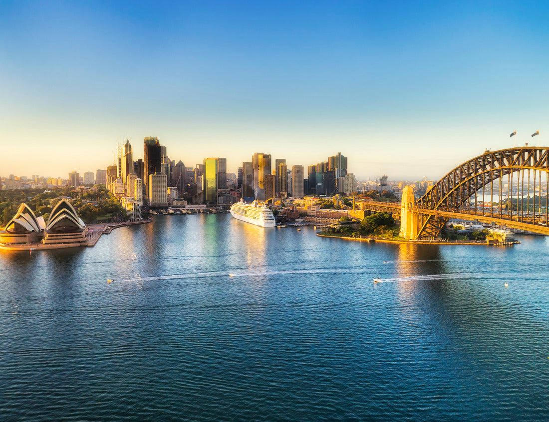 Noah Jigsaw Puzzle Arch of the Sydney Harbour bridge across Sydney harbour to The Rocks and Circular quay waterfront of city CBD lit by soft morning light between blue waters and sky 1000 pieces