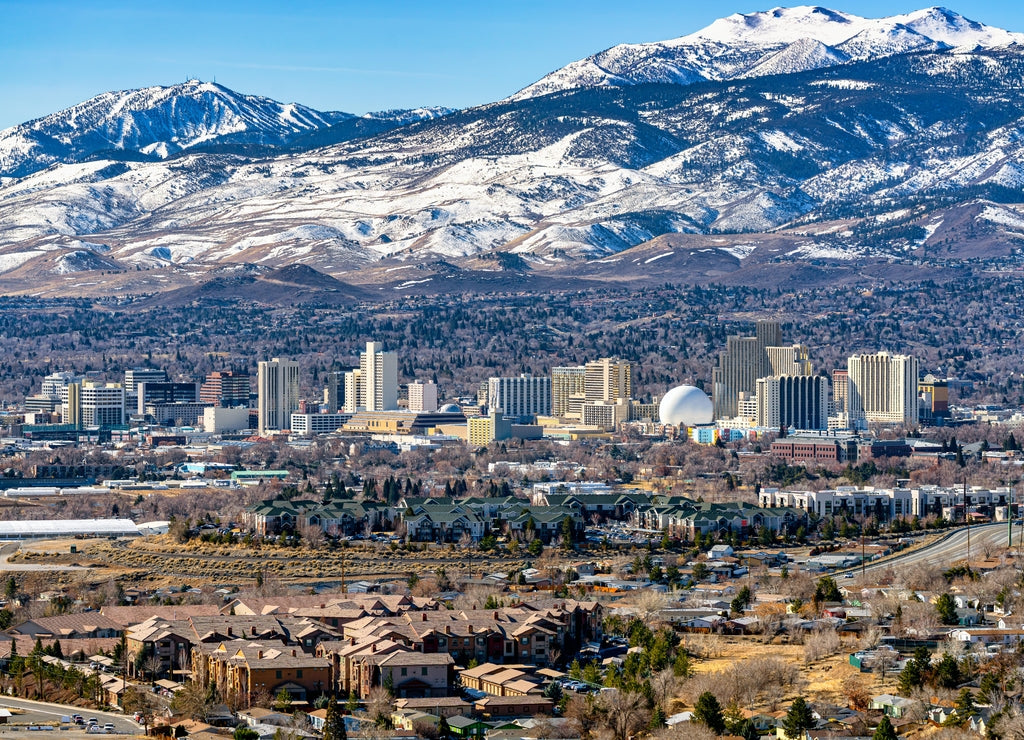 City of Reno Nevada cityscape showing the downtown skyline with Hotels, Casinos and the surrounding residential area with snow capped mountains background