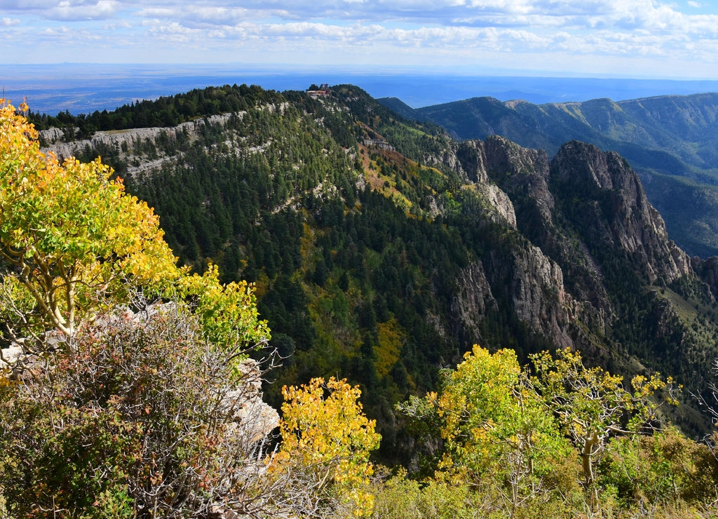 views of granite peaks, evergreens, and changing aspen trees in fall from the top of sandia peak tramway in albuquerque, new mexico