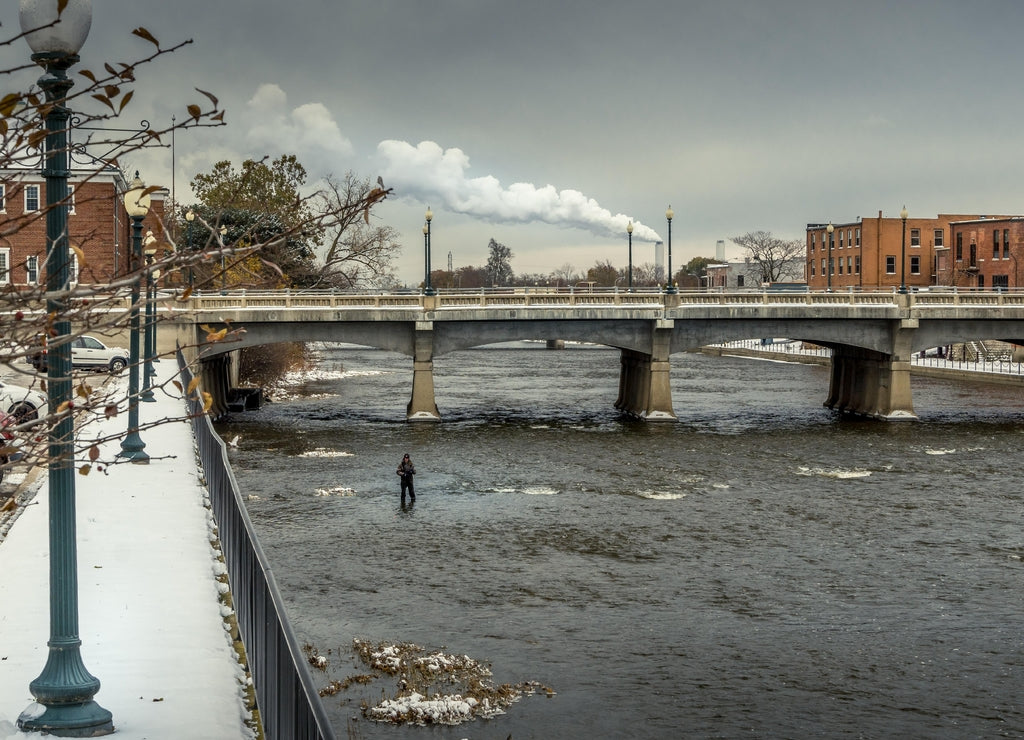 Urban Fisherman standing in the river in downtown Monroe Michigan