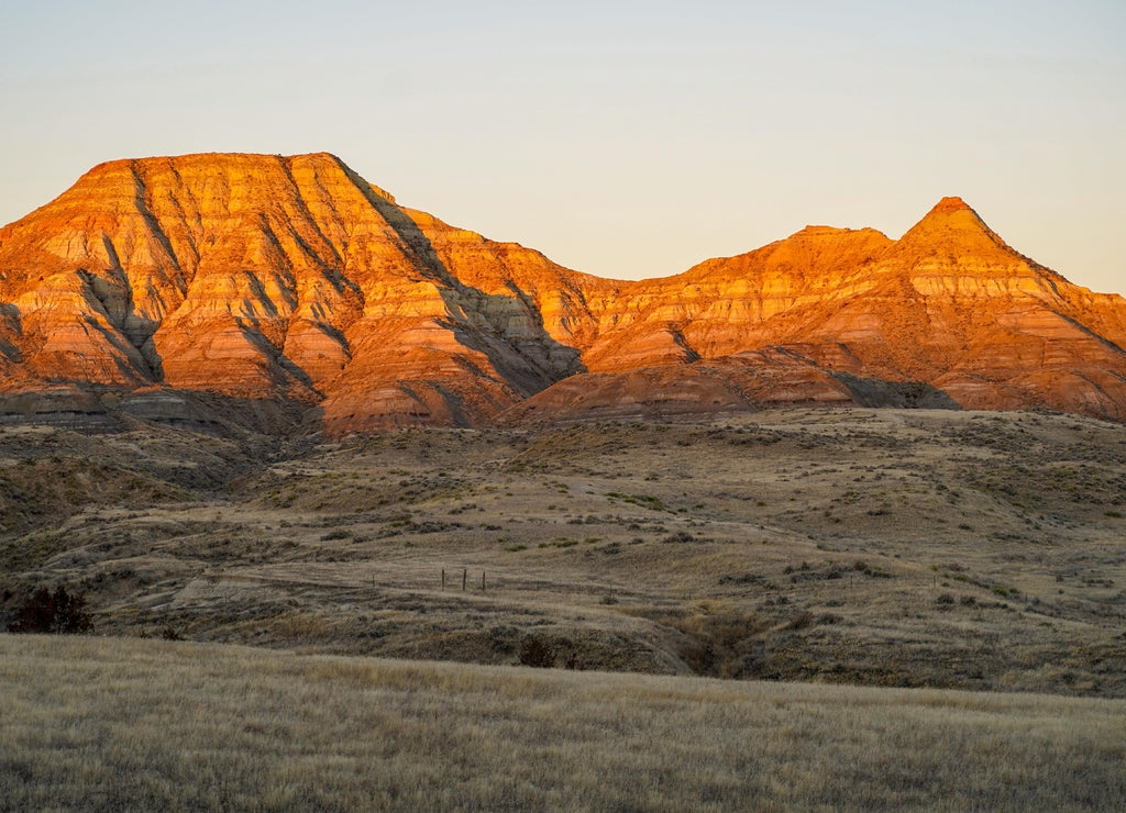 Alpenglow on badlands mountain cliffs in Eastern Montana during sunrise, near Miles City, MT