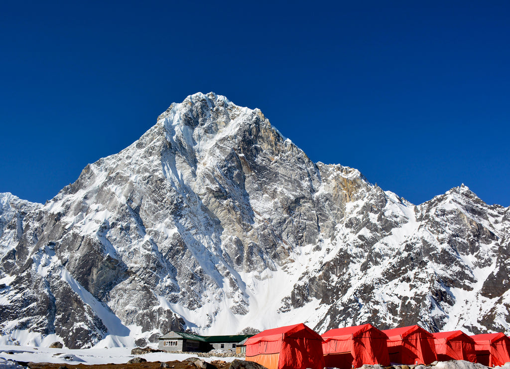 Row of the red tents, way from Cho-La pass to the Everest base camp, Nepal. Magnificent Himalayan mountains on the background
