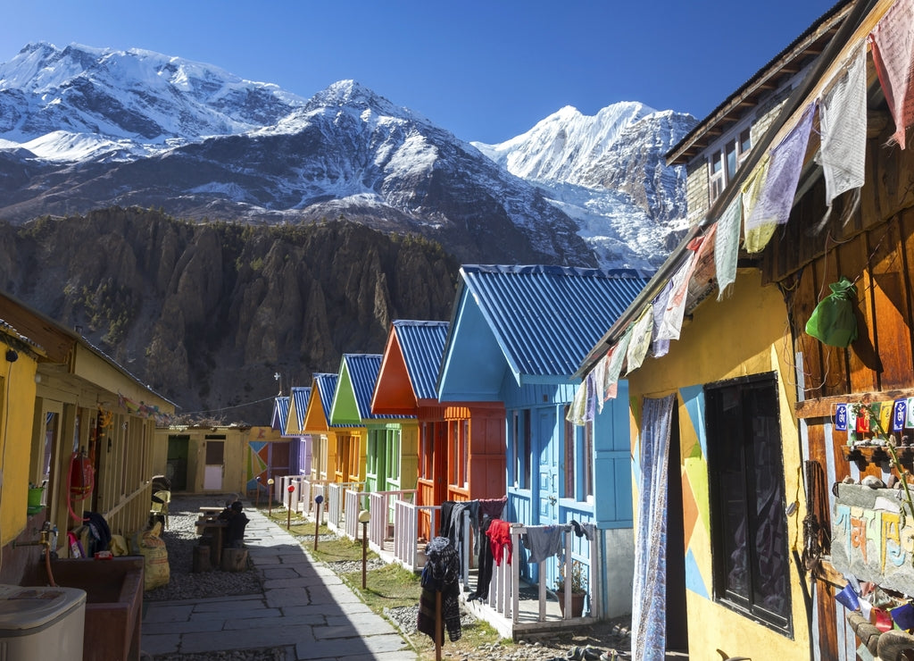 Row of Nepal Village Cottages with Snowy Himalaya Mountain Peaks in the Background on Annapurna Circuit Hiking Trek