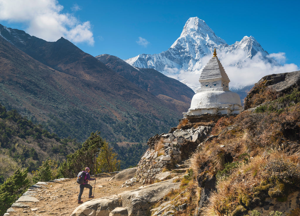 A girl trekking to buddha stupa with view to Ama Dablam peak in Nepal