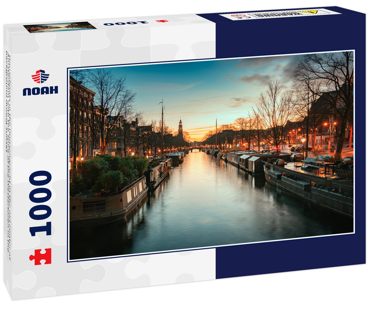 Houseboats in the Prinsengracht in the old center of Amsterdam with the spire of the Westertoren in the background during sunset