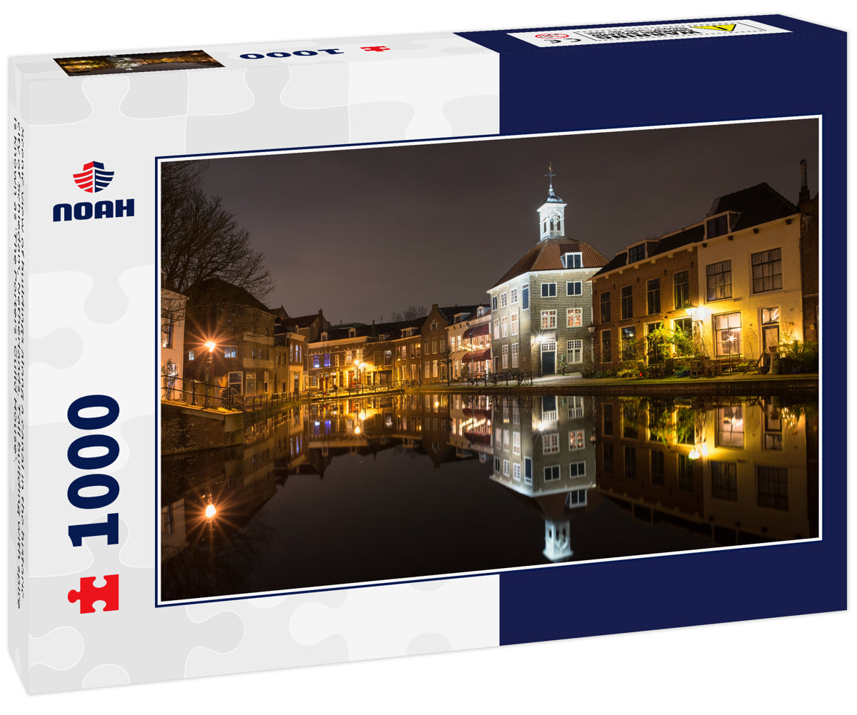 Scenic view of buildings along a canal in the historic city of Schiedam, Netherlands. Tall building with spire is known as 'The Porters' Guild House'.