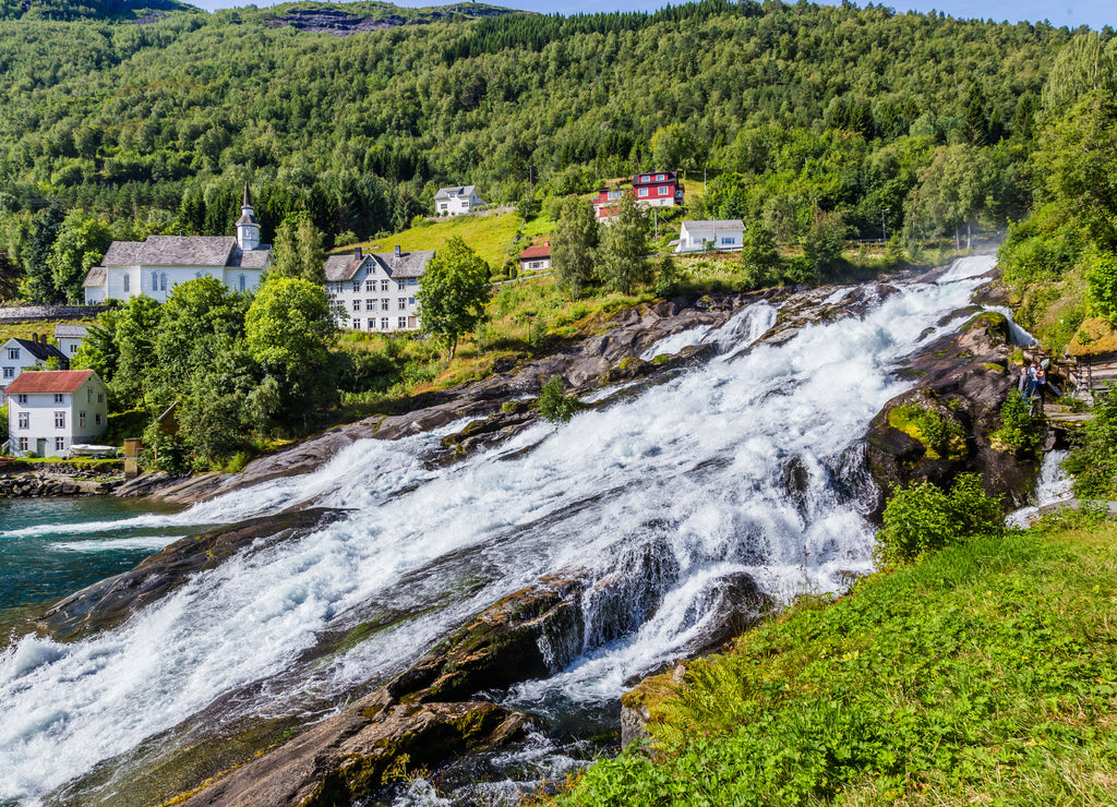 Panorama of small village Hellesylt with Hellesyltfossen waterfall in along Geiranger fjord in More og Romsdal county in Norway