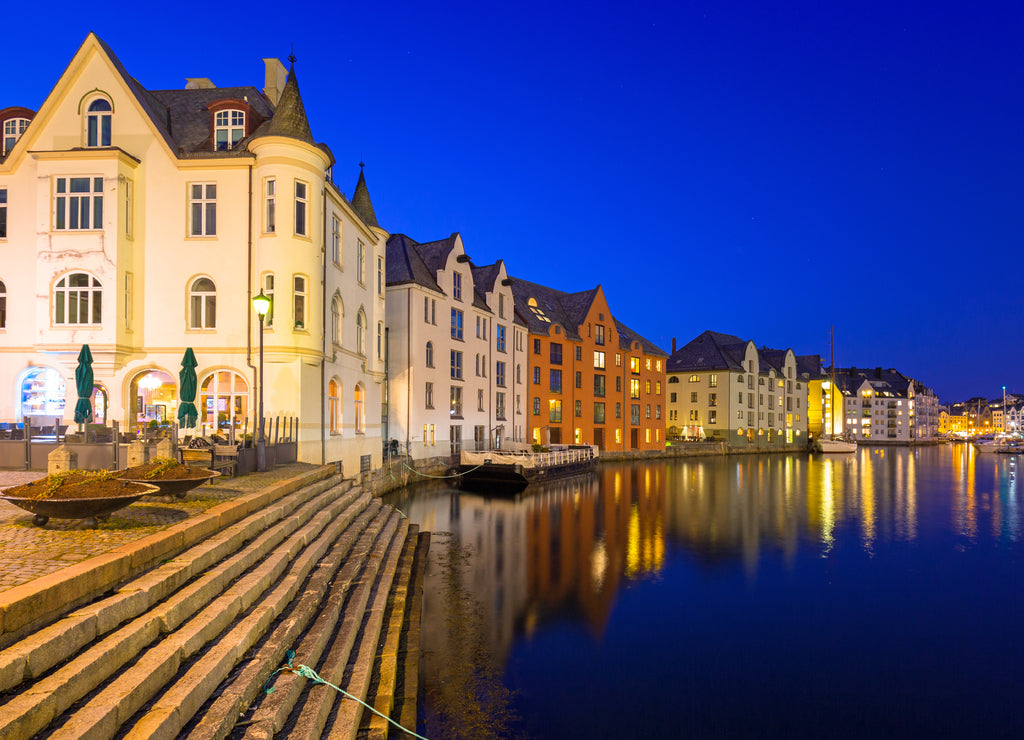 Architecture of Alesund city reflected in the water at night, Norway