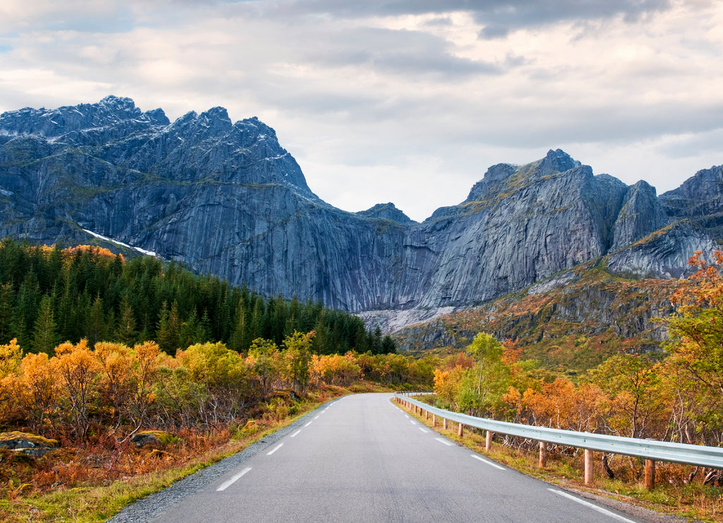 road in Norway, Lofoten Islands, golden autumn at the rocky wall of the mountains