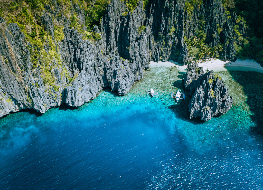 El Nido, Palawan, Philippines. Aerial above view of banca boats surrounded by karst scenery rocks at Secret Lagoon beach